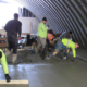 Several cement mason apprentices receiving on-the-job training while pouring and finishing concrete.
