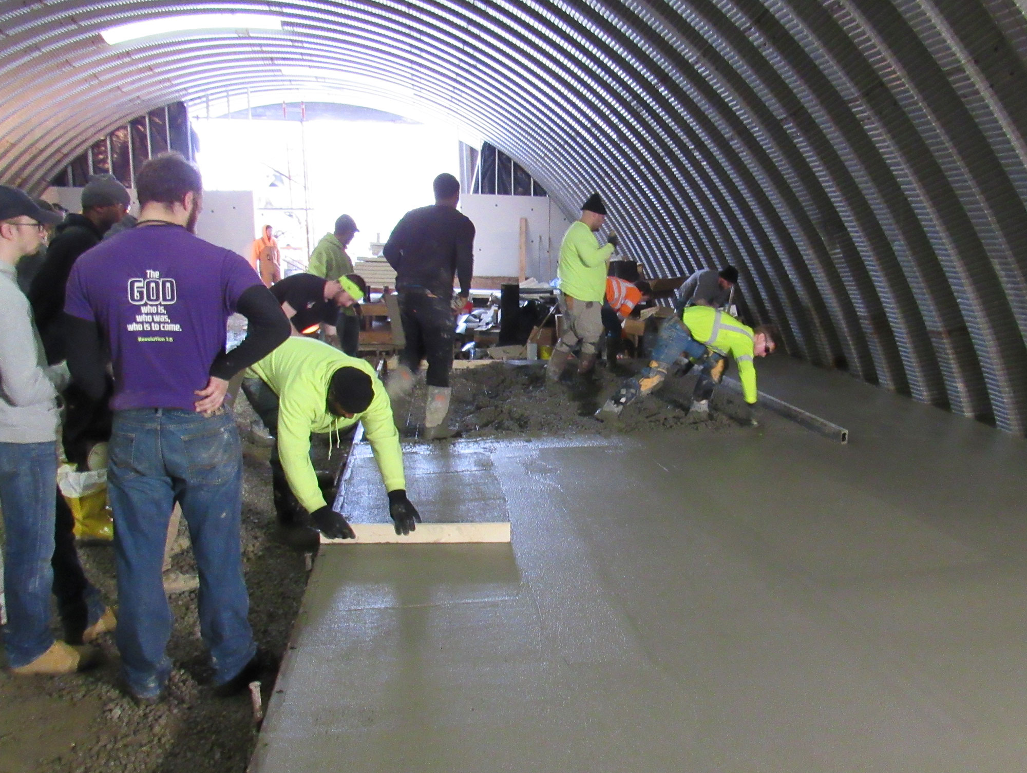 Several cement mason apprentices receiving on-the-job training while pouring and finishing concrete.