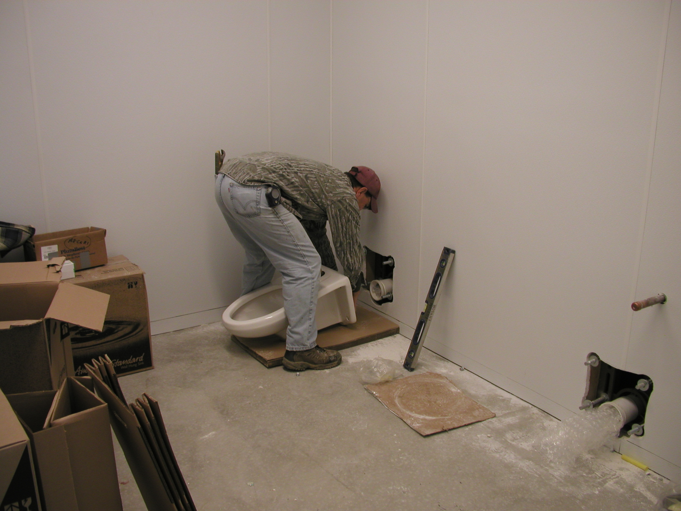 Plumber installing toilet