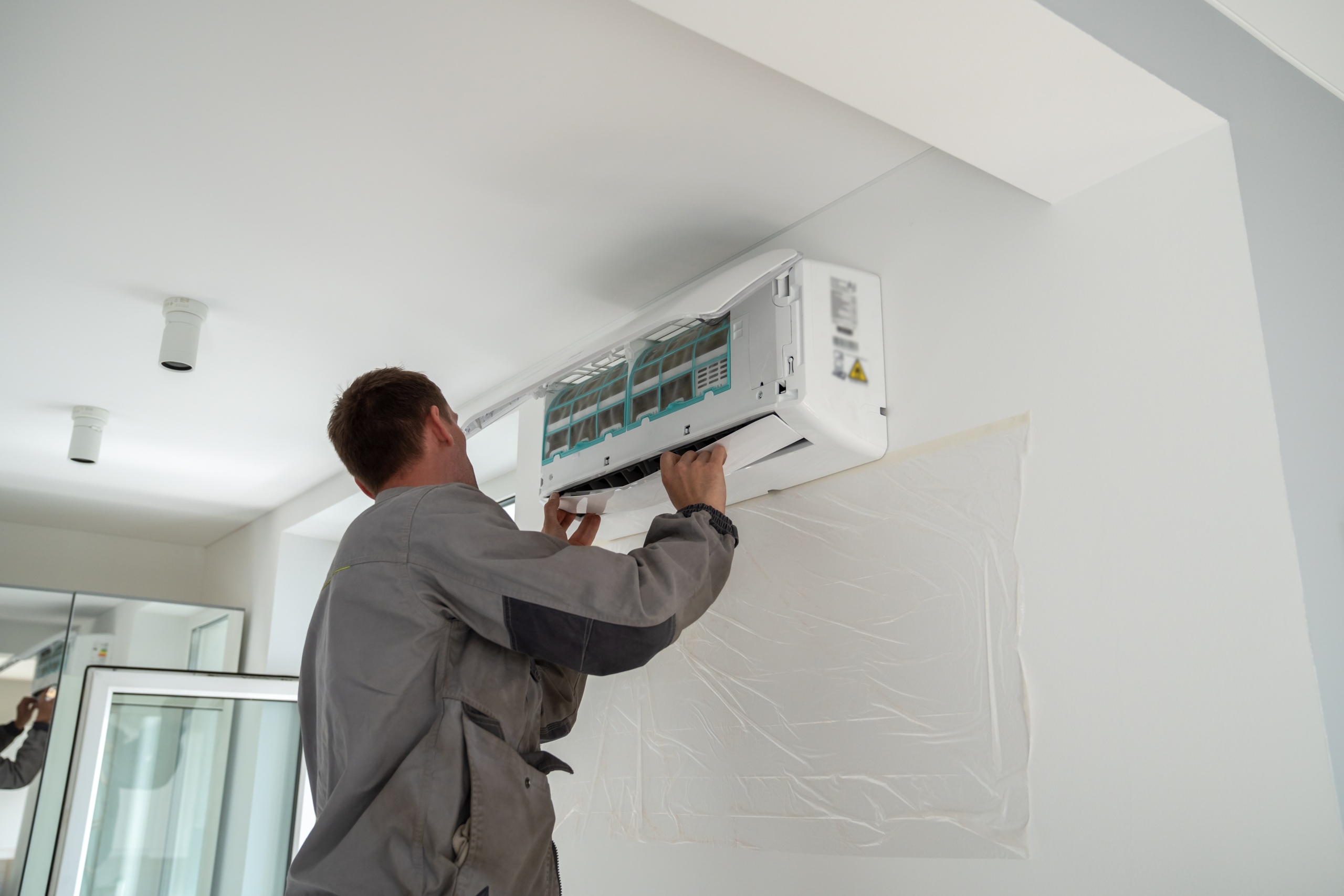 HVAC worker installing A/C unit