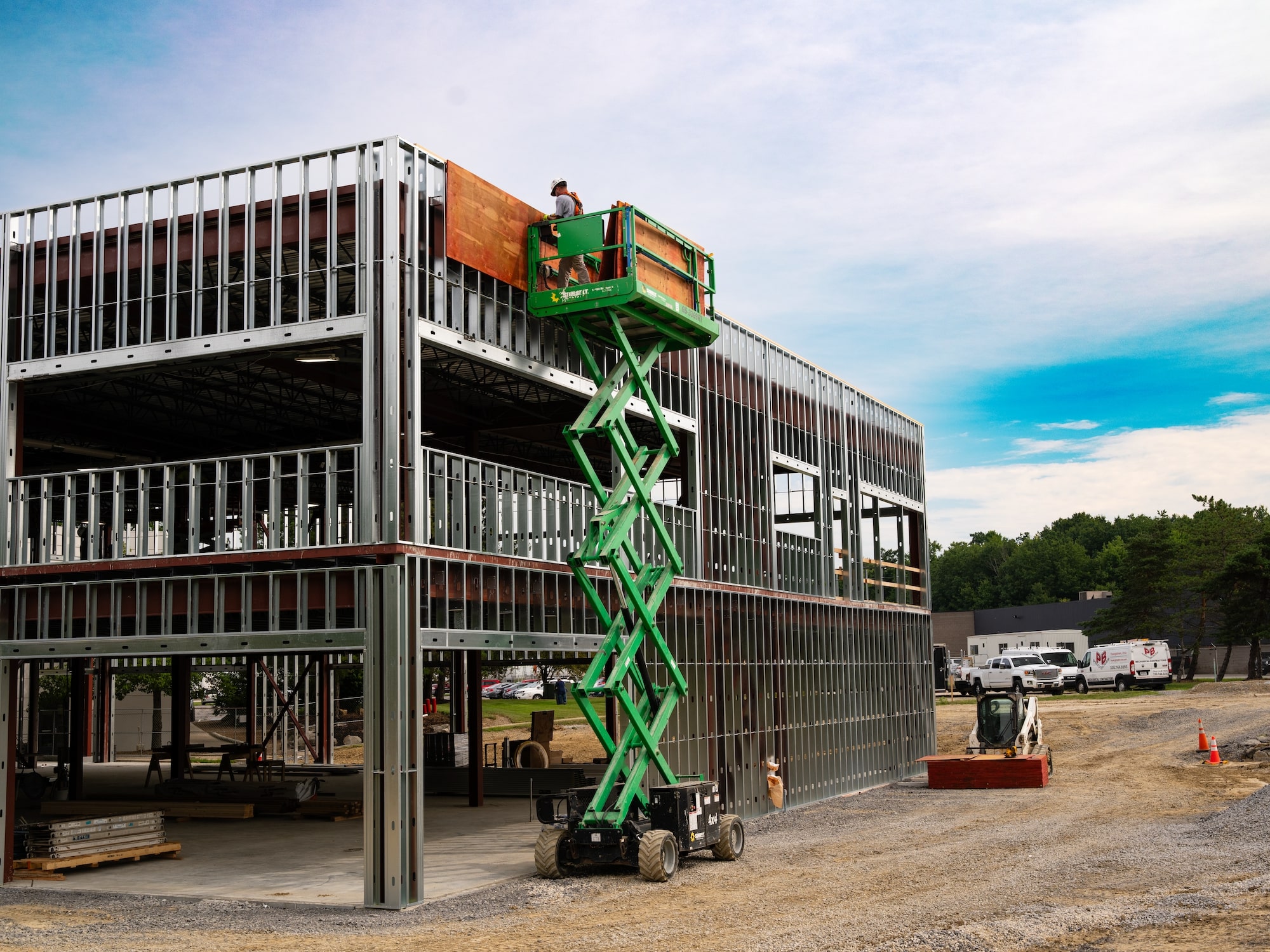 Metal building structure with employees on electric lift outside