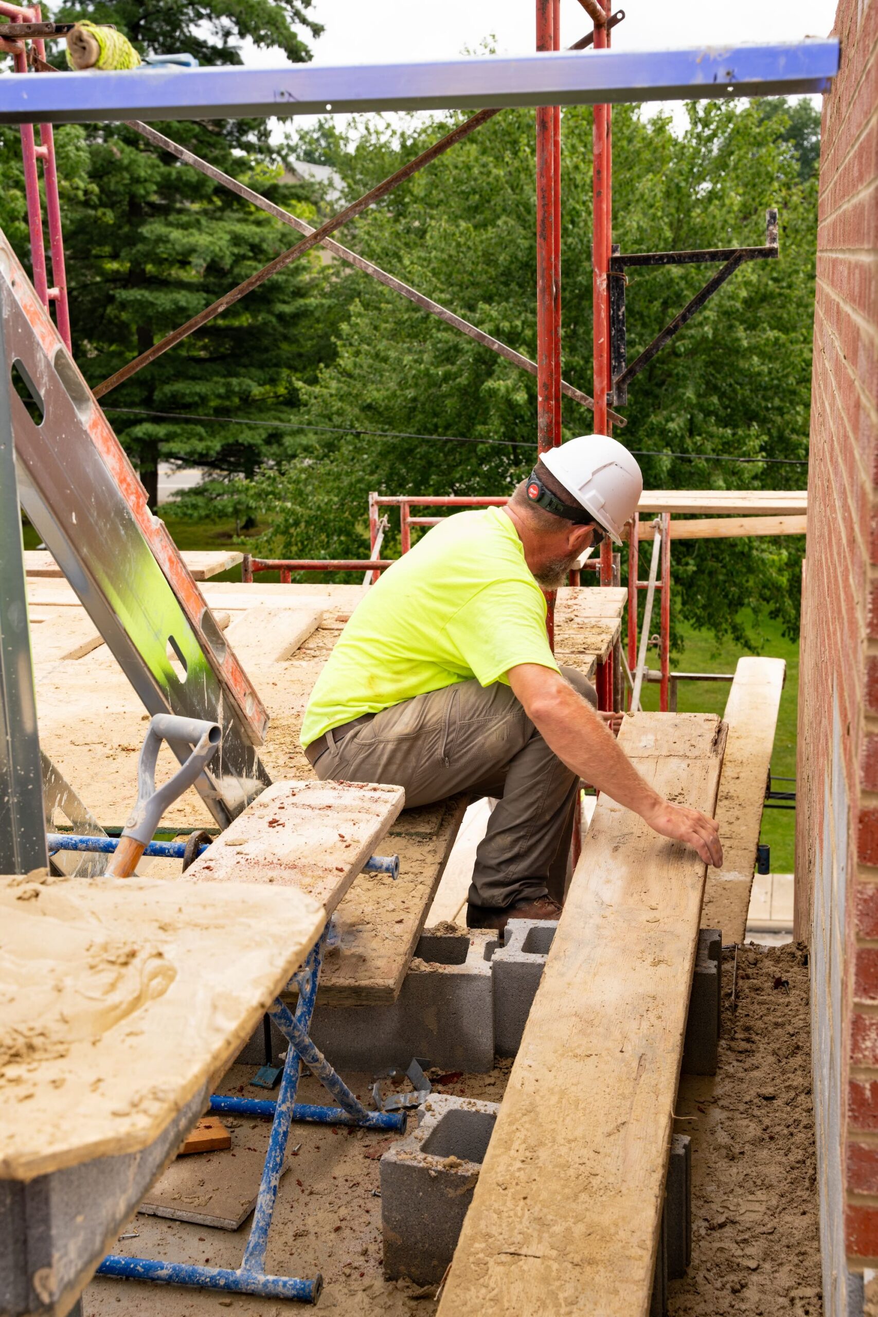 Construction worker wearing neon shirt, hard hat outside working